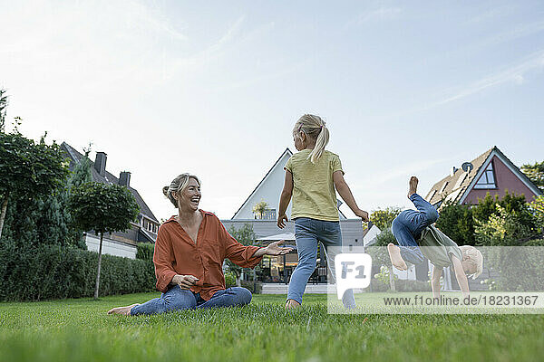 Cheerful mother with son and daughter enjoying in garden