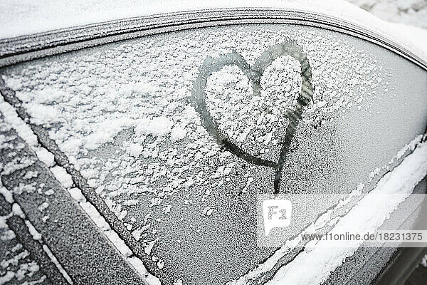Heart shape on frosted car window in winter