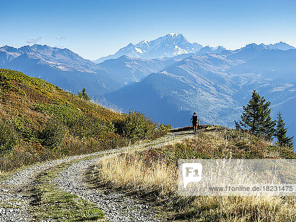 Mann  der an einem sonnigen Tag vor den Bergen im Nationalpark Vanoise  Frankreich  spaziert