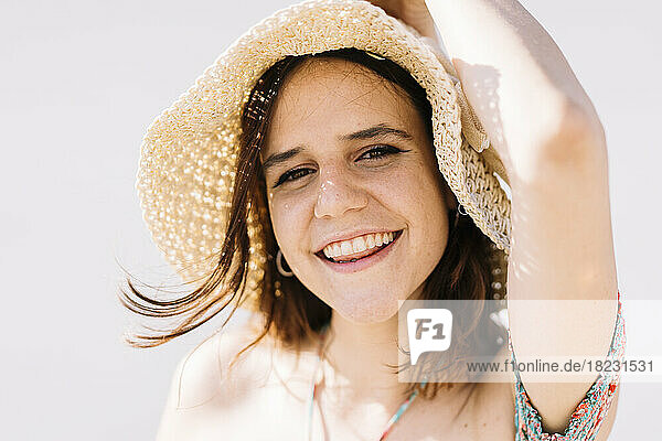 Happy woman wearing hat on sunny day