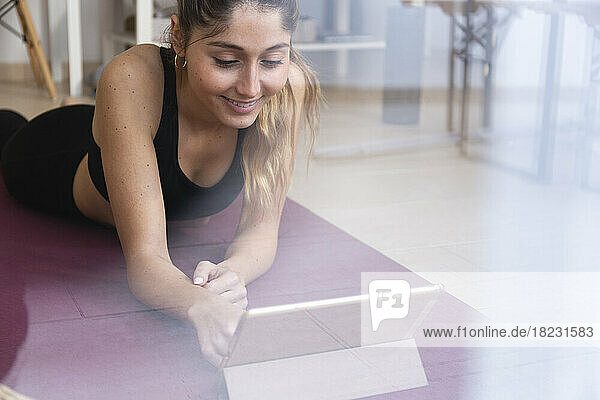 Happy young woman using tablet PC at home