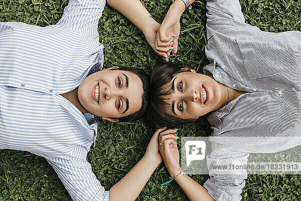 Lesbian couple relaxing on grass