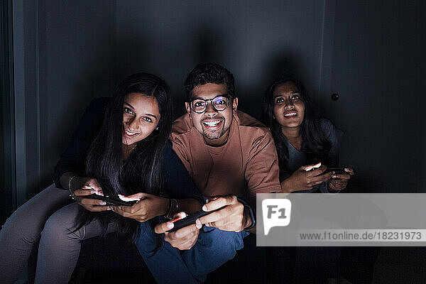 Happy man and women playing game in room at home