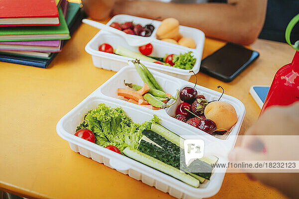 Fresh fruit and vegetable in lunch box on table