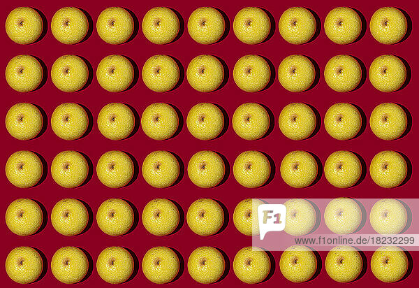 Pattern of halved lemons flat laid against red background