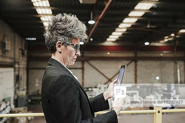 Mature businesswoman using tablet PC at factory