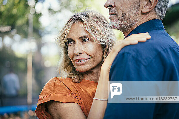 Smiling woman standing with man in back yard
