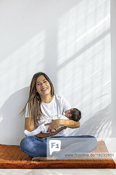 Happy woman with newborn baby girl at home