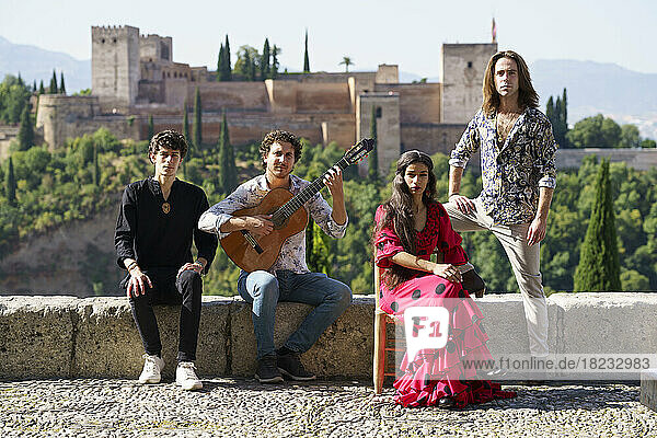 Flamenco musicians and dancers sitting on wall in front of Alhambra  Granada  Spain
