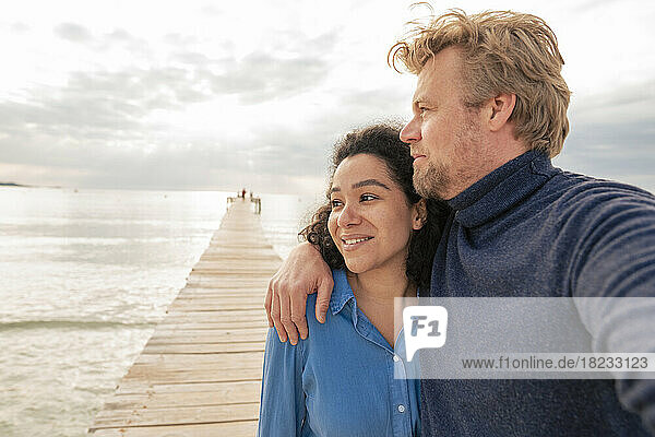 Thoughtful couple standing together on jetty
