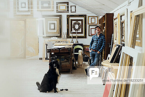 Mature man standing with dog in workshop