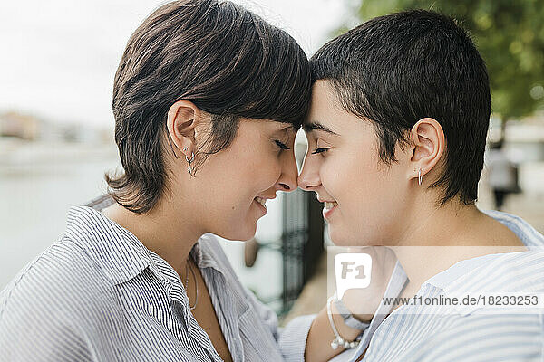 Lesbisches Paar kuschelt sich mit geschlossenen Augen