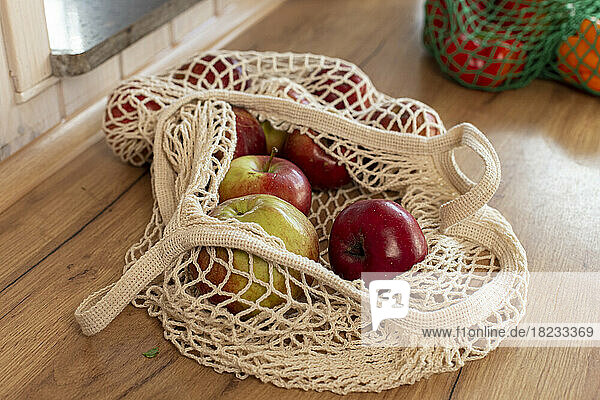 Apples in a mesh bag on kitchen counter