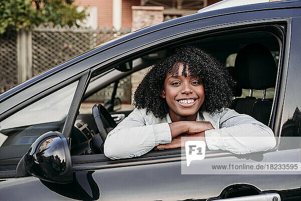Smiling woman leaning on car's window