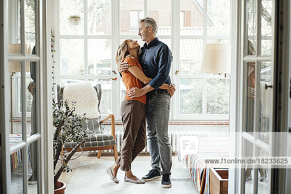 Glückliches reifes Paar  das sich zu Hause umarmt und umarmt