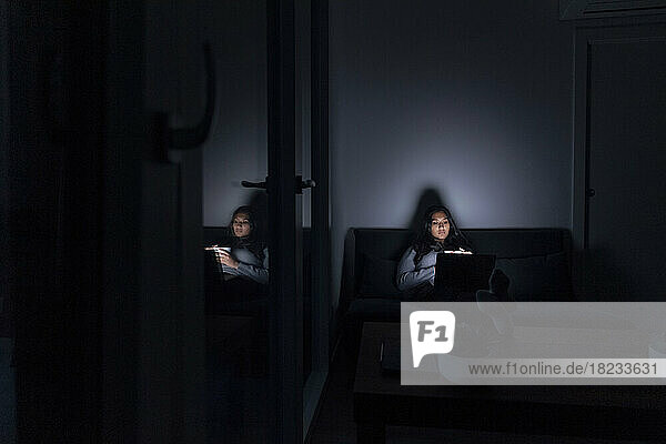 Young woman with laptop in room at home