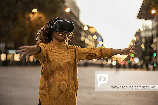 Woman wearing virtual reality simulator gesturing on footpath