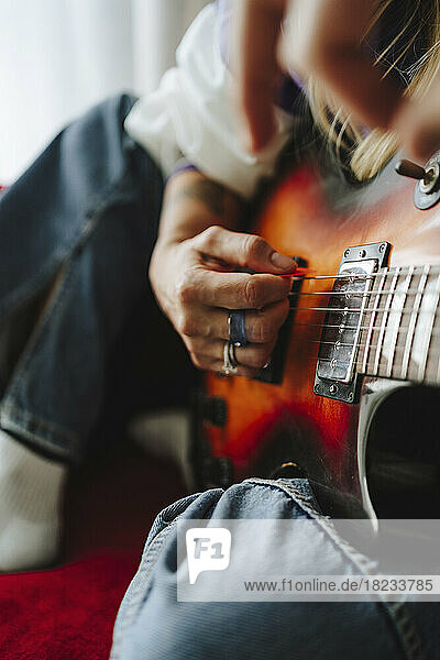 Hand of guitarist playing electric guitar in studio