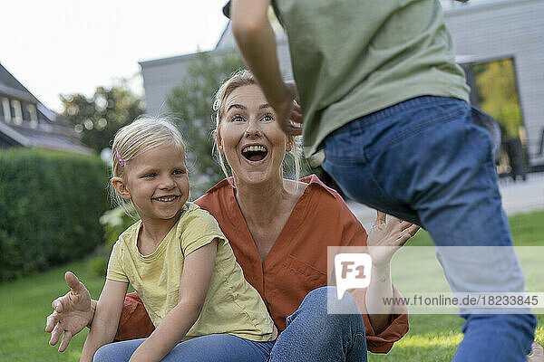 Glückliche Mutter genießt es mit Sohn und Tochter im Hinterhof