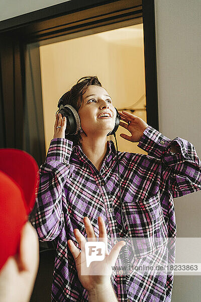 Singer wearing headphones in front of colleague at studio