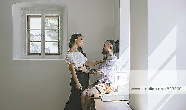 Romantic hipster couple by wall at home