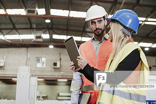 Engineers having discussion over tablet PC at industry
