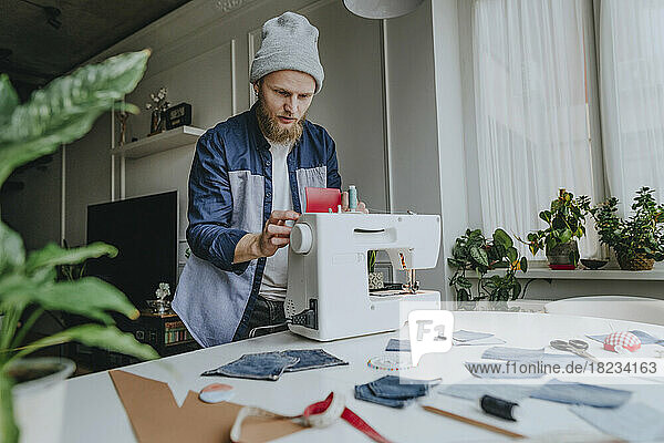 Modedesigner stellt Nähmaschine in Werkstatt ein