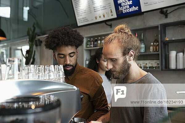 Barista and colleague working in cafe