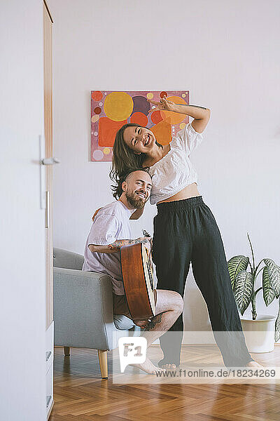 Cheerful couple having fun in living room at home