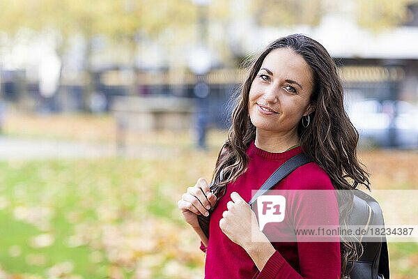 Beautiful woman with backpack in park