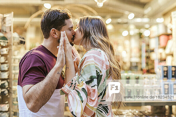 Affectionate man and woman kissing each other in store