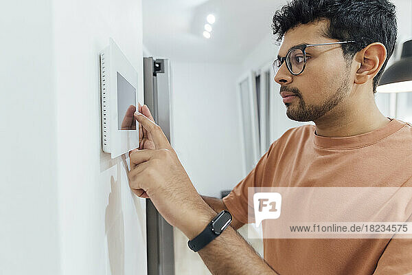 Man using smart home device on wall
