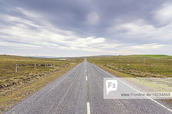 UK  Scotland  Unst  Clouds over empty asphalt road in Shetland Islands