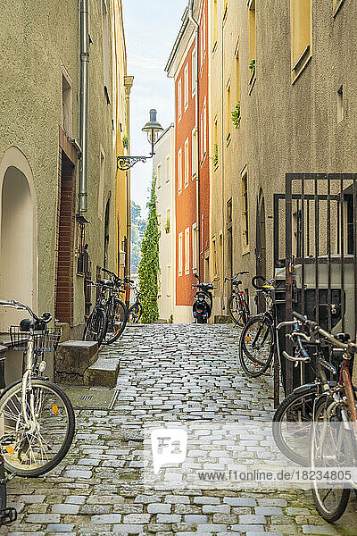Germany  Bavaria  Passau  Bicycles left along cobblestone alley