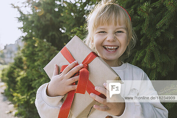 Fröhliches Mädchen mit Weihnachtsgeschenkbox