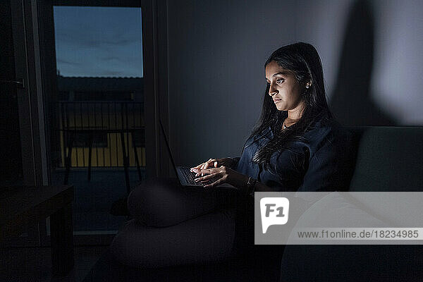 Woman using laptop in room at home