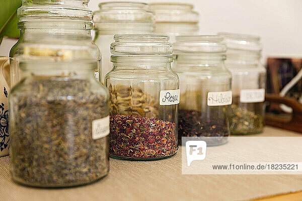 Herbs in jars arranged on table