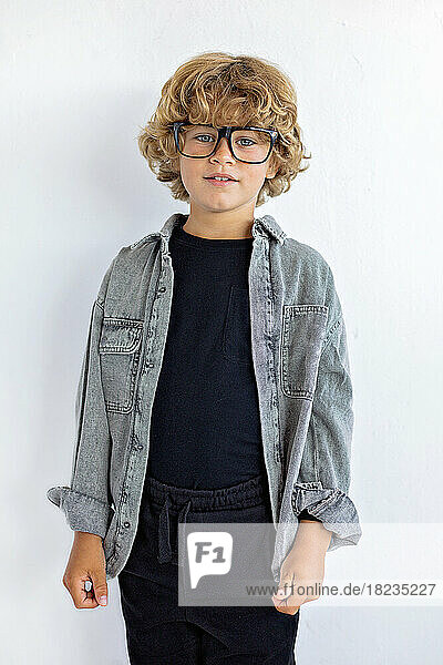 Boy wearing eyeglasses against white background