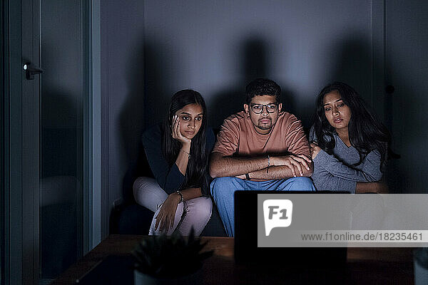 Young man and women watching movie on TV at home