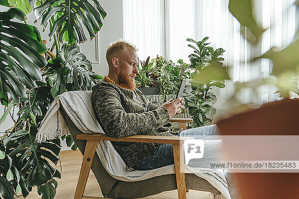 Man using mobile phone sitting on chair at home