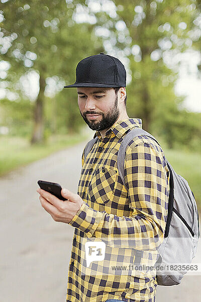 Man looking at mobile phone on road