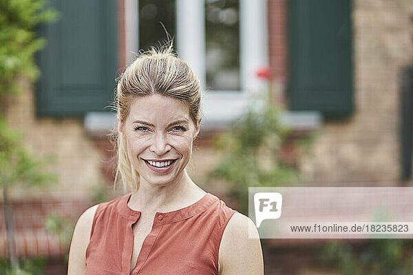 Lächelnde Frau vor dem Haus