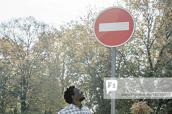 Lächelnder Mann blickt auf das Schild „Zutritt verboten“.