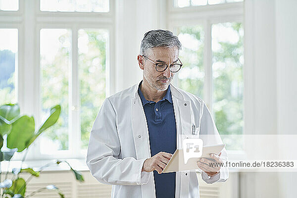 Mature doctor using tablet PC in medical practice