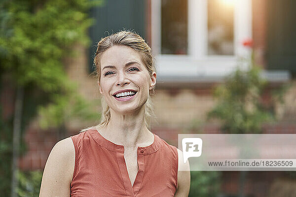 Happy woman in front of house