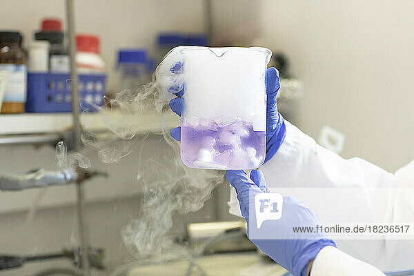 Hands of scientist experimenting with liquid nitrogen in laboratory