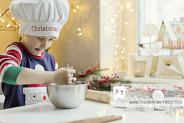 Boy preparing gingerbread dough in kitchen at home