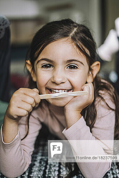 Porträt eines lächelnden Mädchens  das in einer Kindertagesstätte Eis isst
