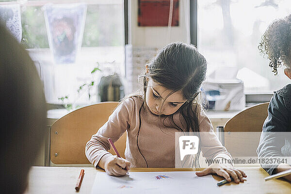 Mädchen Färbung in Buch mit Bleistift Farbe von weiblichen Freund in der Kindertagesstätte