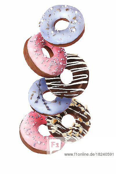 Süße mehrfarbige Donuts auf weißem Hintergrund in der Schwebe